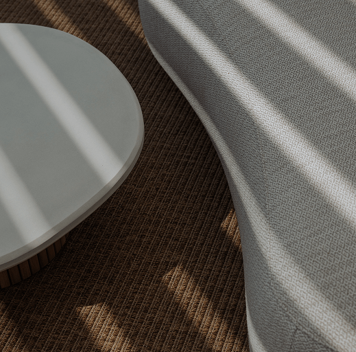 Close-up of organic shaped coffee table in front of a luxury outdoor sofa