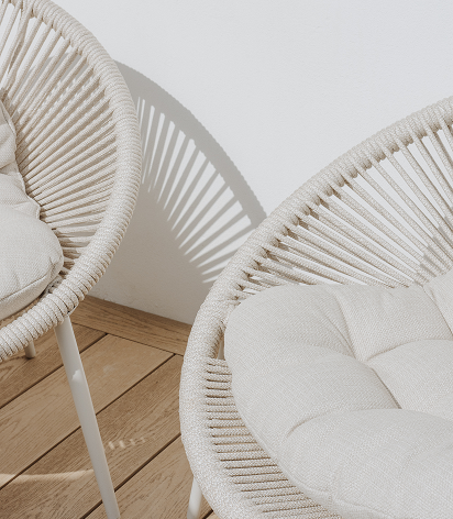 Two beige outdoor chairs with pillows