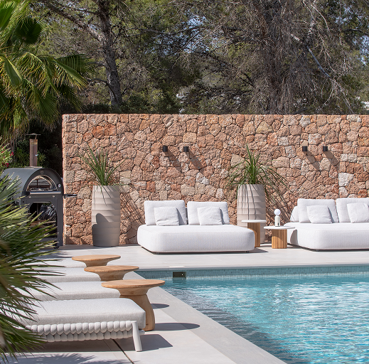 Lounge beds in front of swimming pool with planters