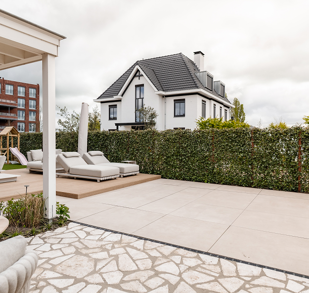 Natural stone paving tiled terrace with poolside loungers on wooden structure