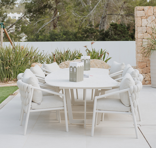 Beige outdoor dining table with six dining chairs with comfortable cushions
