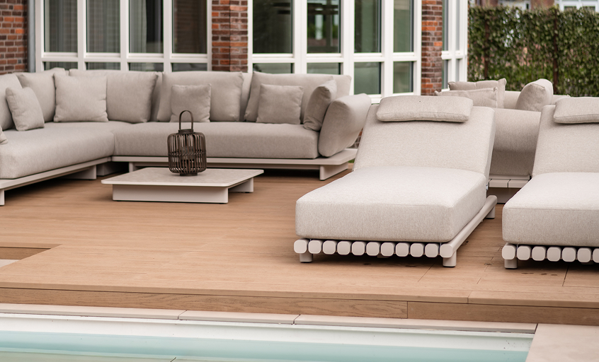 Poolside sunbeds in a lounge corner with big outdoor sofa behind