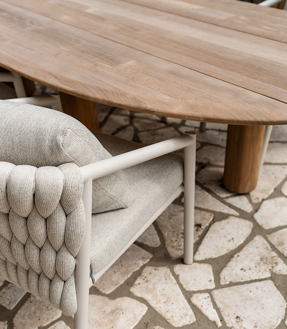 Close-up of wooden outdoor table with premium woven dining chair