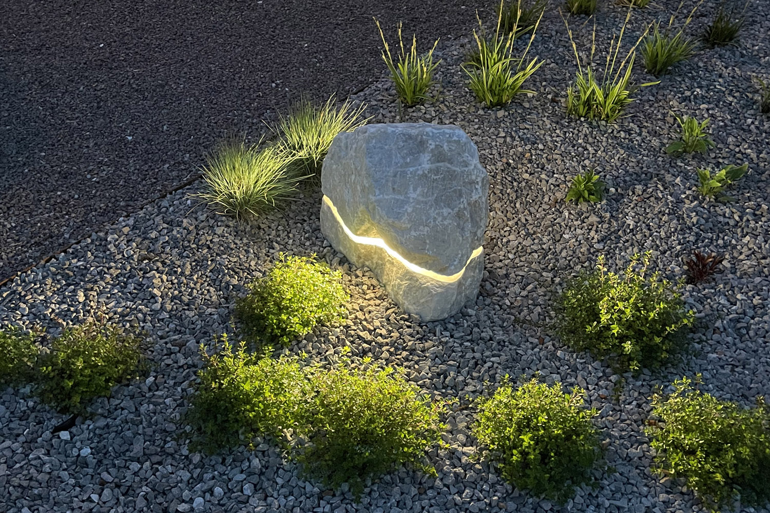 Menhir di Luce outdoor lamp illuminating garden path at dusk