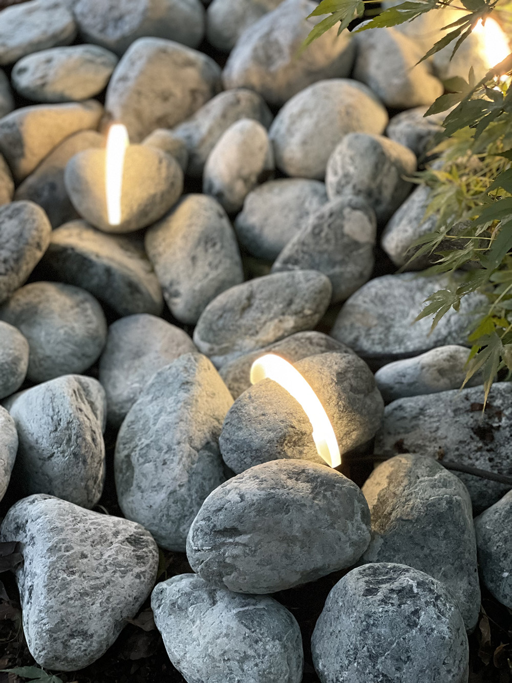 Ray outdoor light illuminating decorative stones in the garden